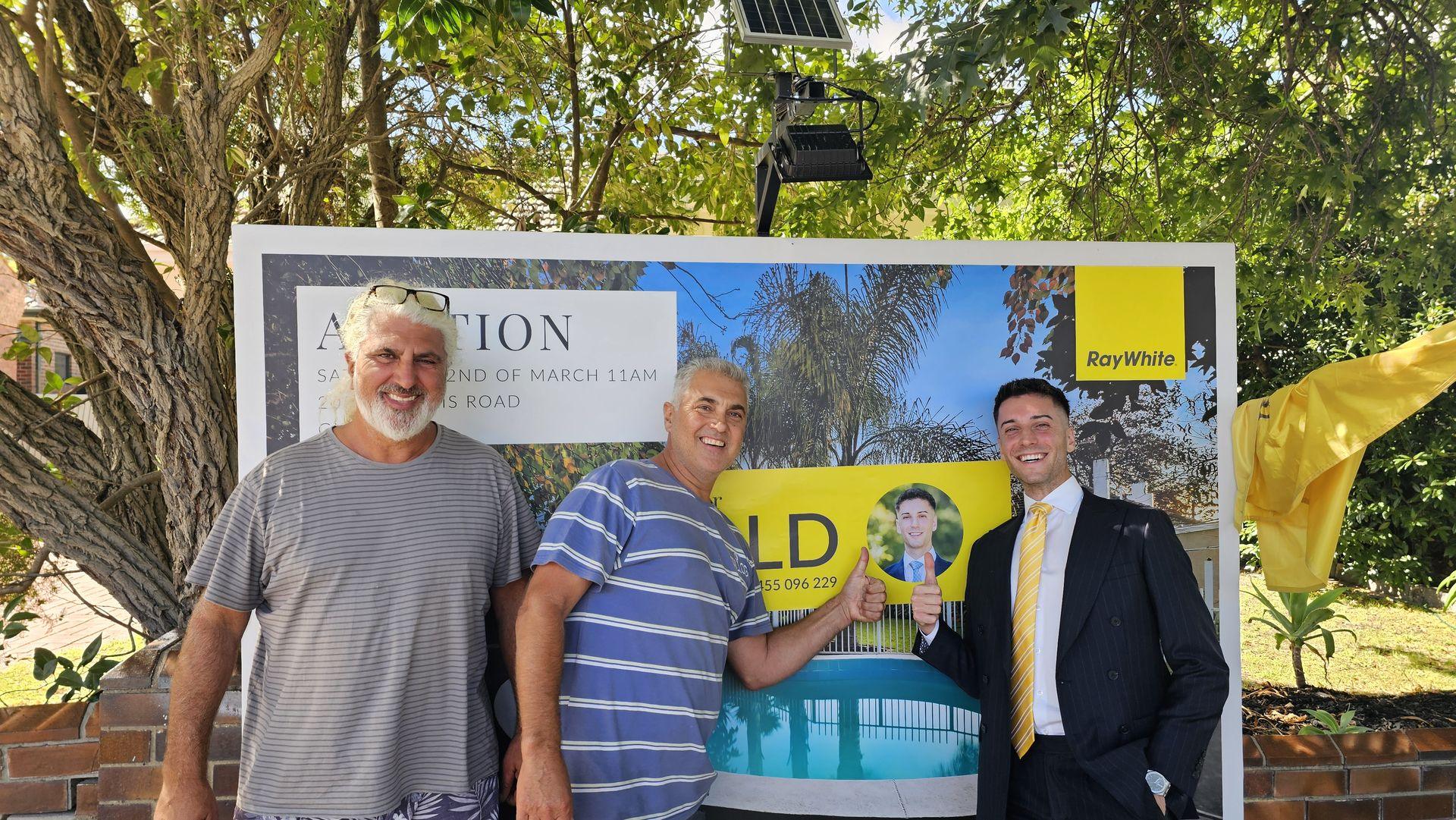 Sold on auction day with Pavlou Brothers Ray White sold board with happy vendors on auction day in Melbourne