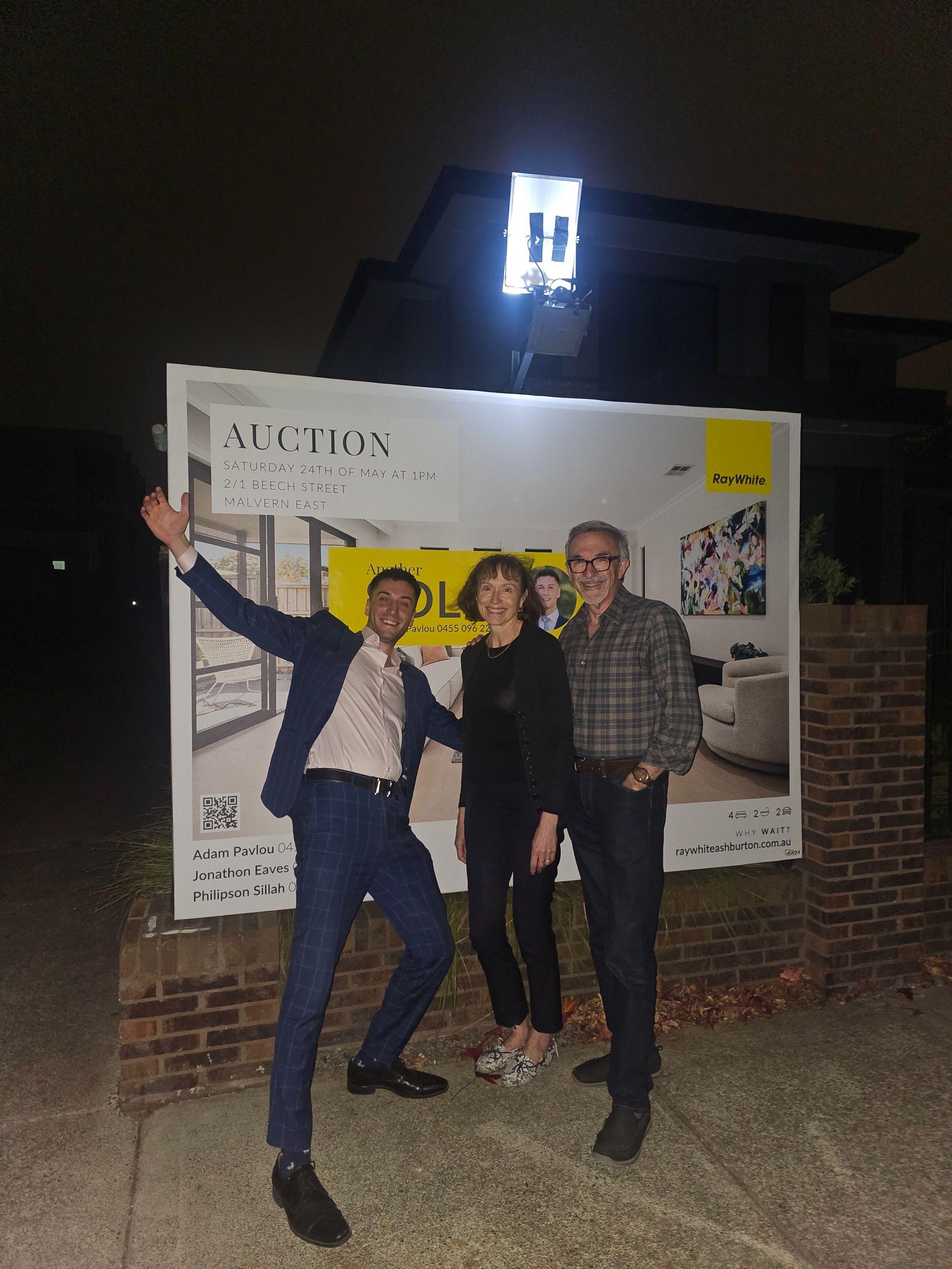 Vendors celebrating a sold under the hammer result at a Ray White auction